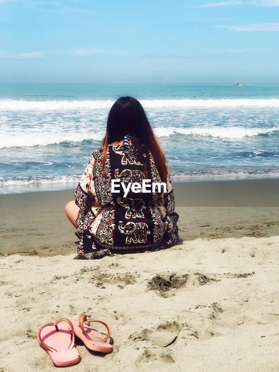 Woman on beach by sea against sky