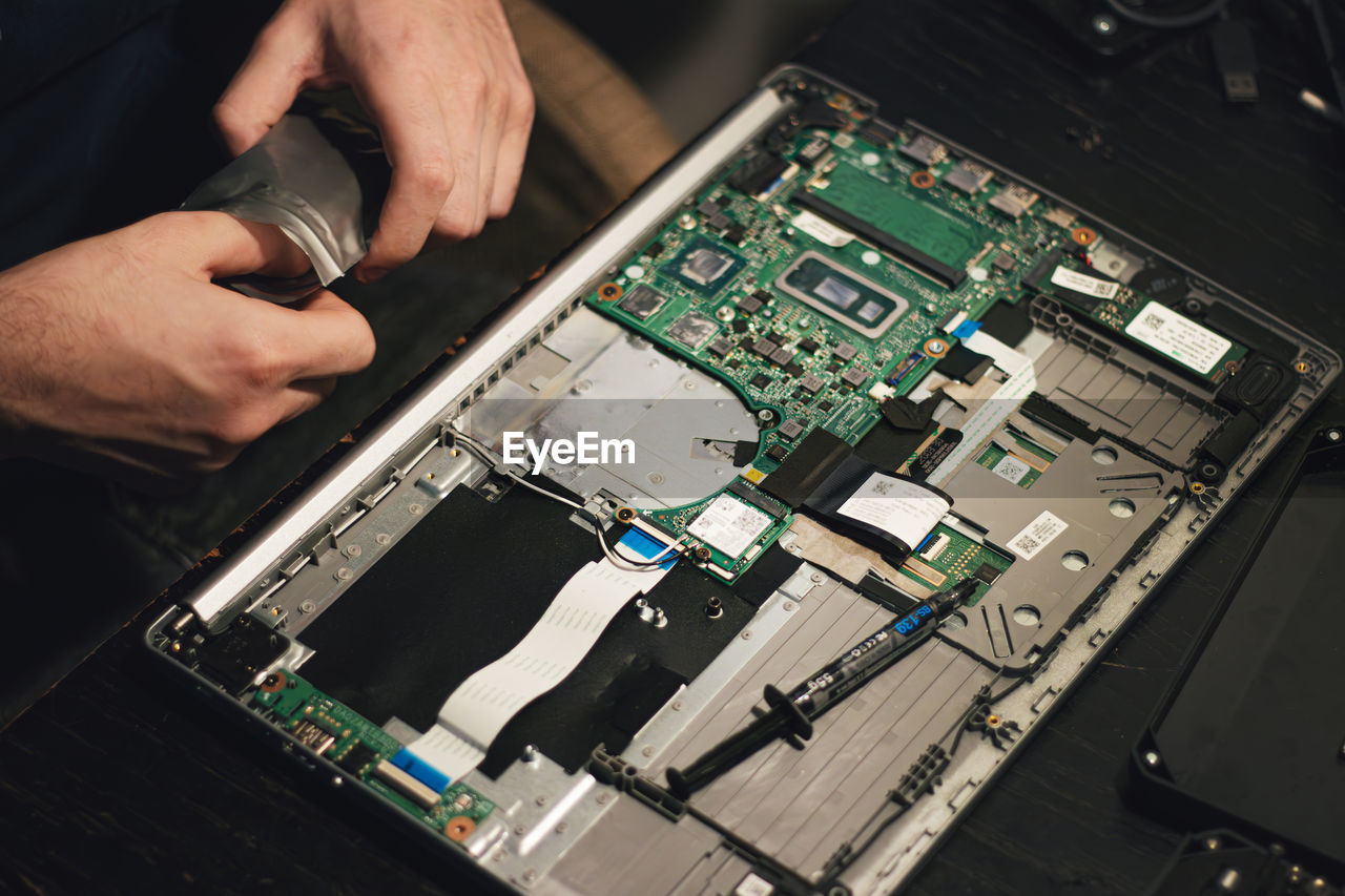 Cropped hands repairing circuit board