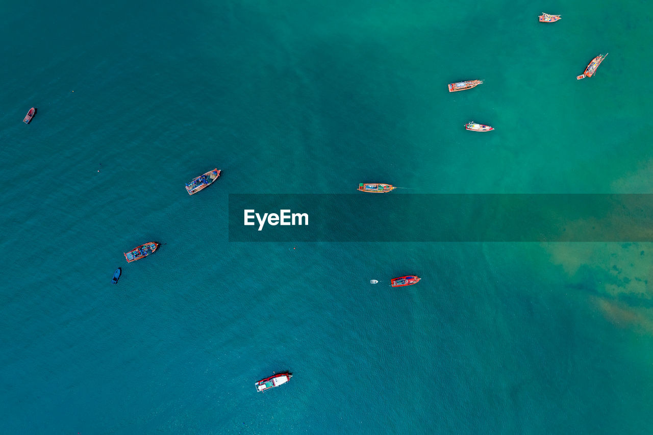 Fishing boat sailing on the green sea background abstract aerial top view