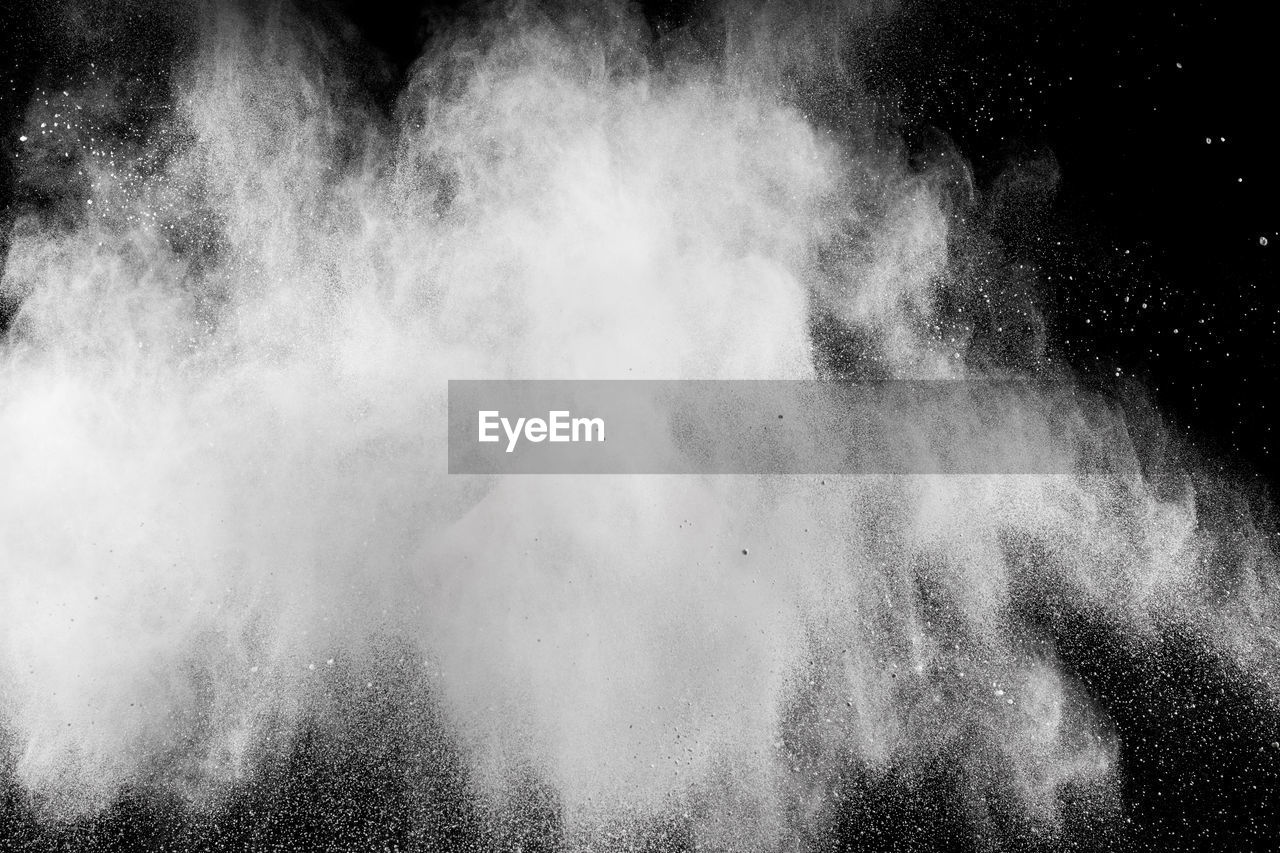 Close-up of exploding dust against black background