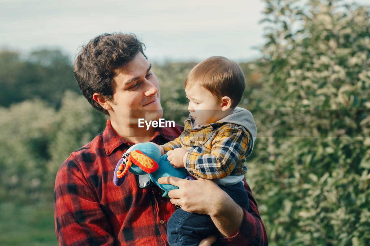 Father holding son while standing in park