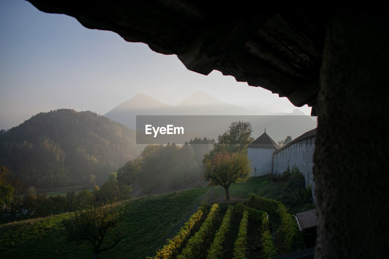 Scenic view of field by mountains against sky