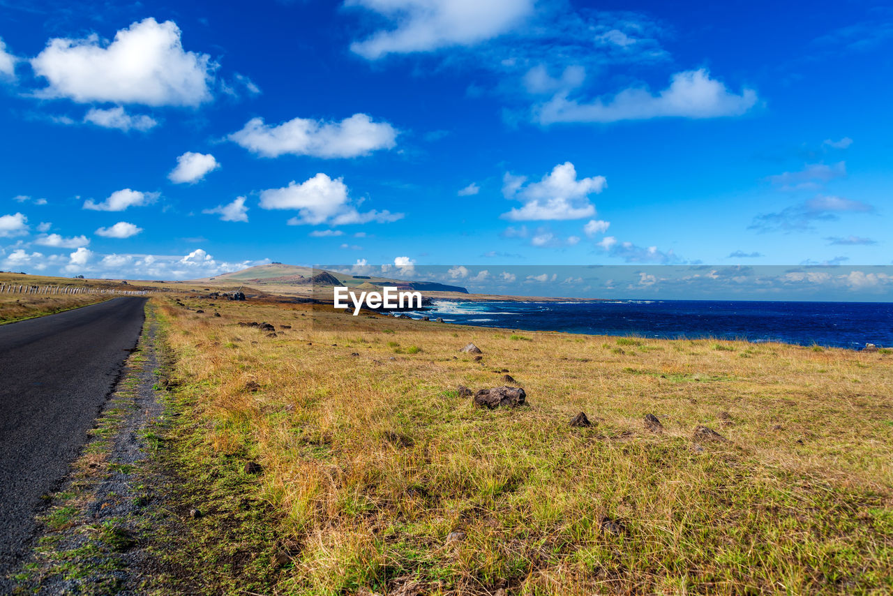 Low angle view of paved road near the sea