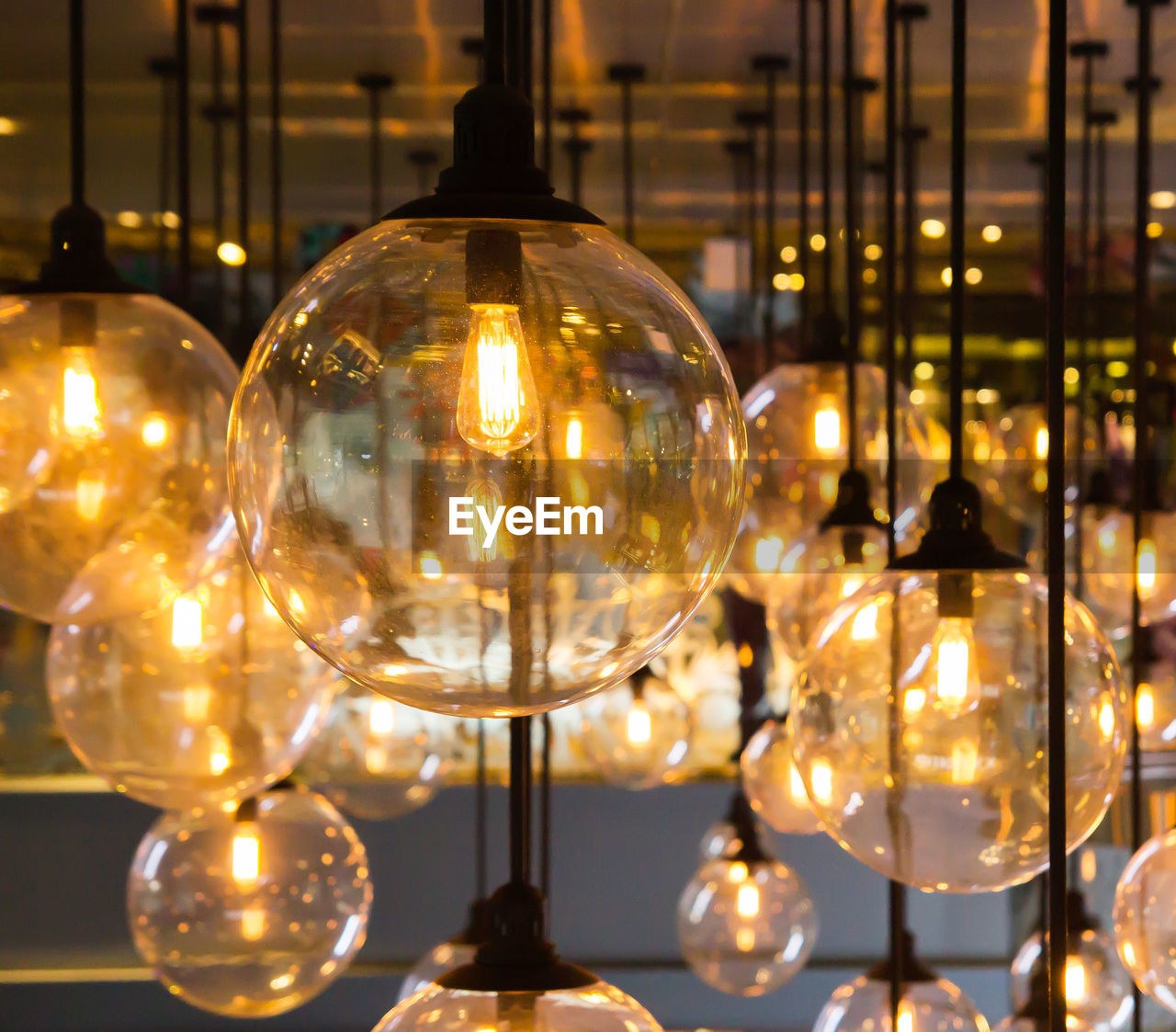 Close-up of illuminated light bulb hanging at night