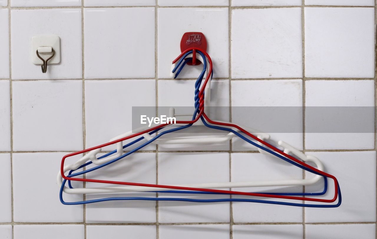 Close-up of coathangers hanging on hook in bathroom