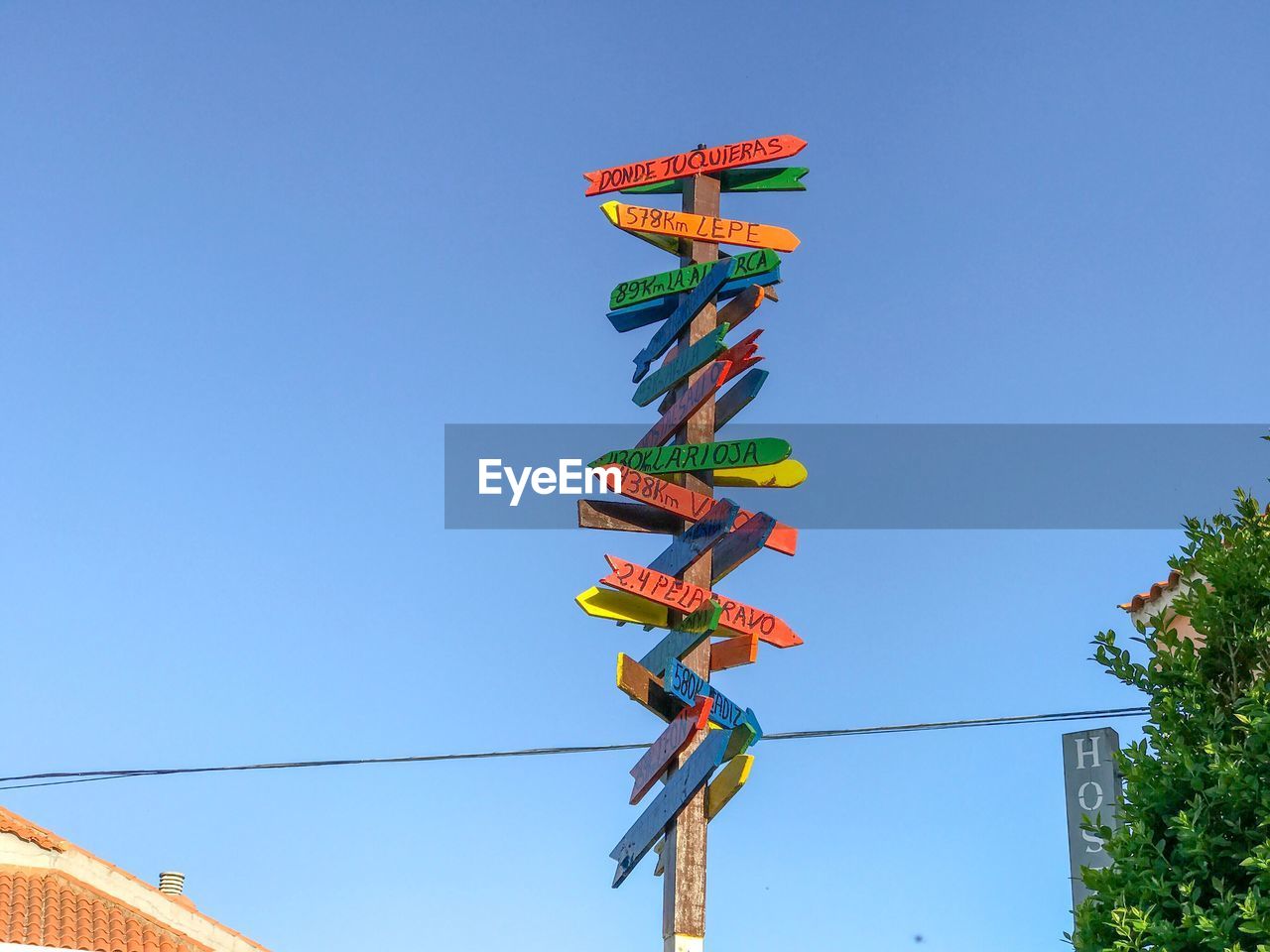 Low angle view of directional signs on pole against clear blue sky