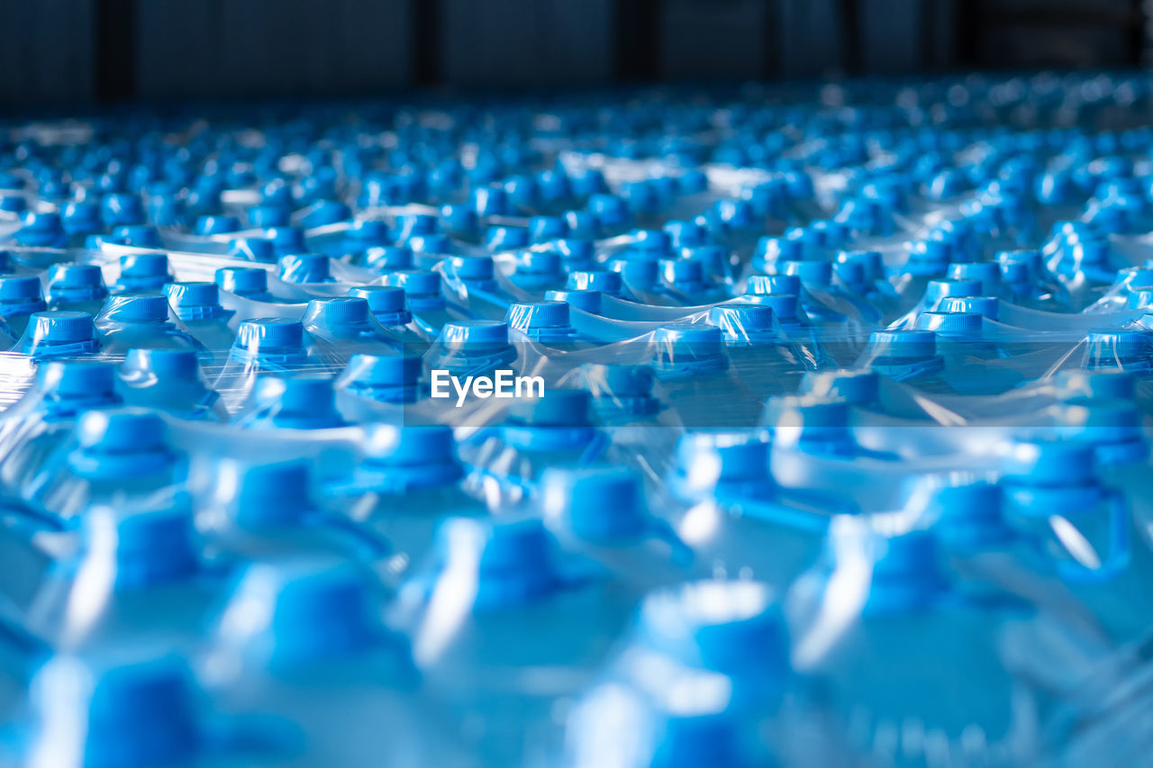 Background image of blue plastic bottles with blue cap and handle in packaging