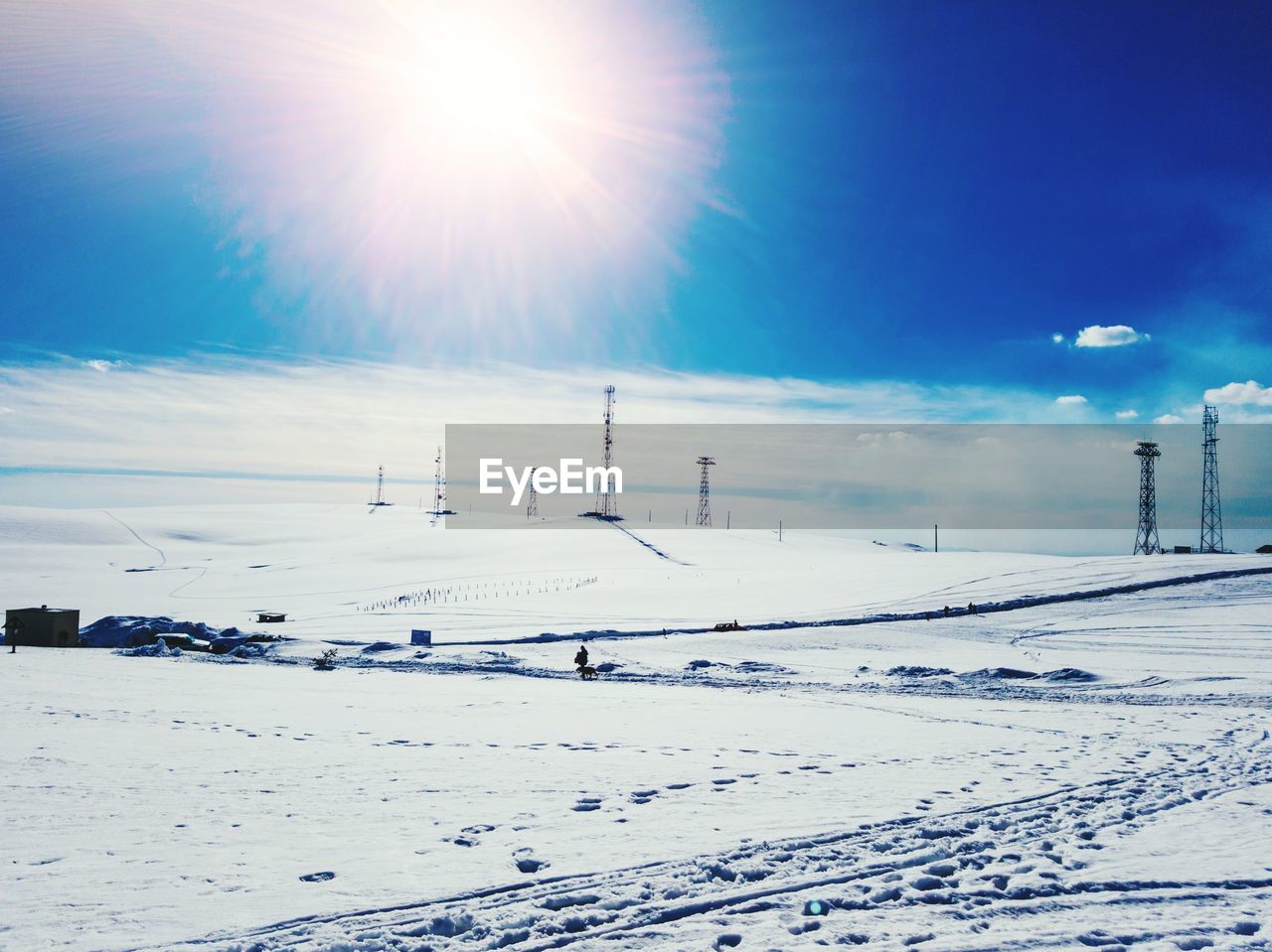 Scenic view of snow covered landscape against bright sun