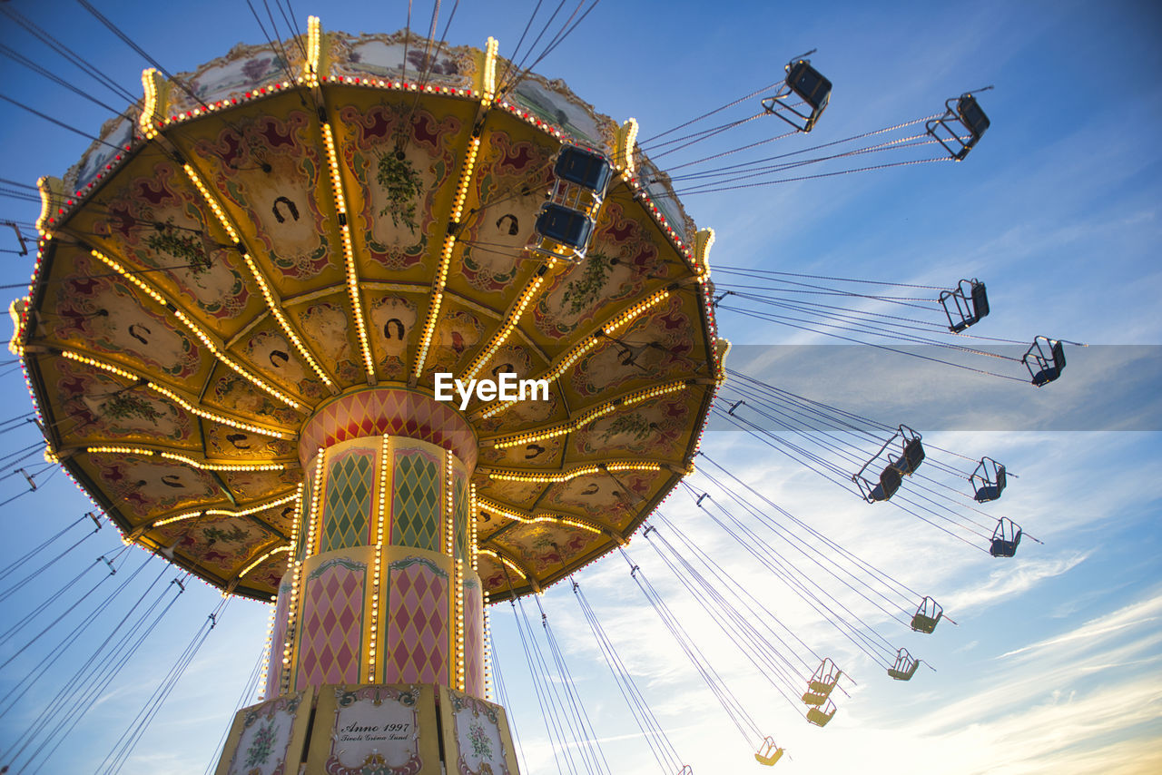 LOW ANGLE VIEW OF CAROUSEL RIDE AGAINST SKY