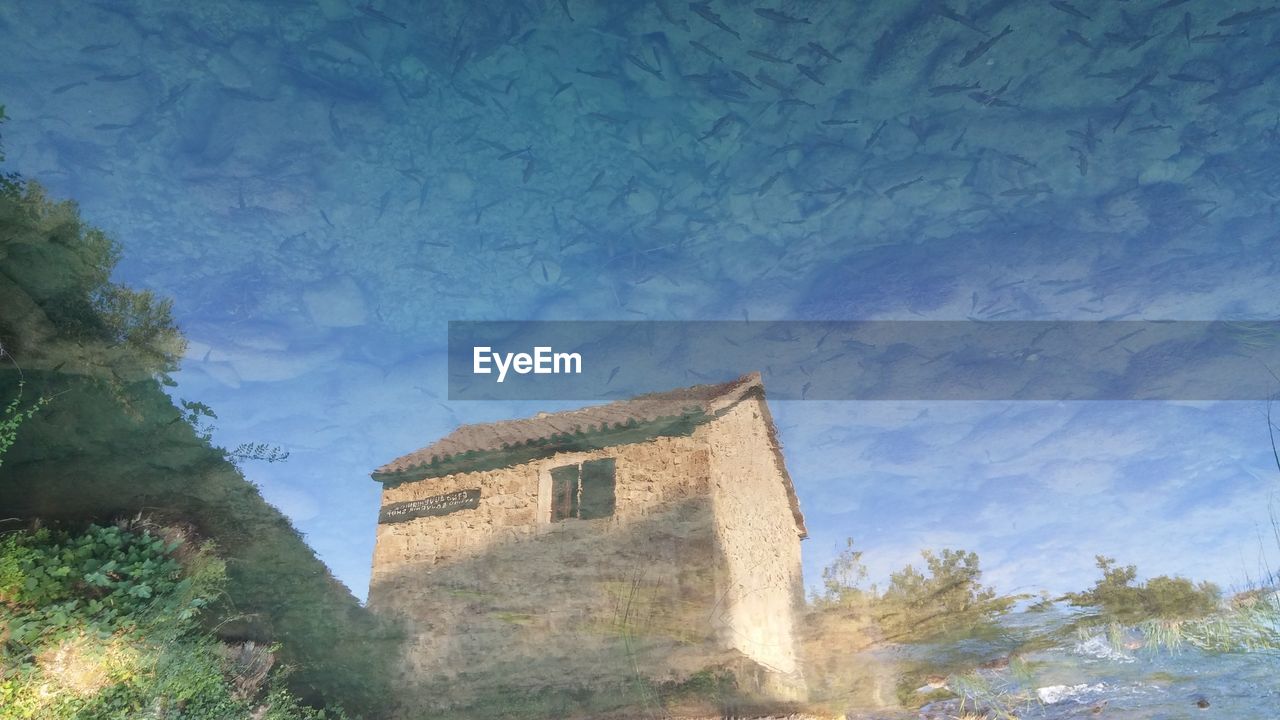 LOW ANGLE VIEW OF BUILT STRUCTURE AGAINST BLUE SKY