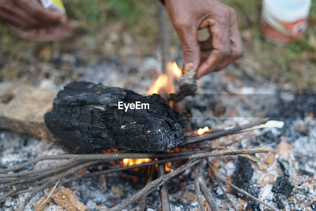 Close-up of hand holding burning outdoors