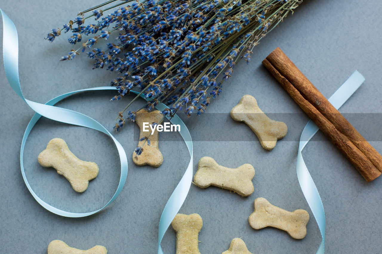 Dog biscuits with cinnamon and lavender on gray background