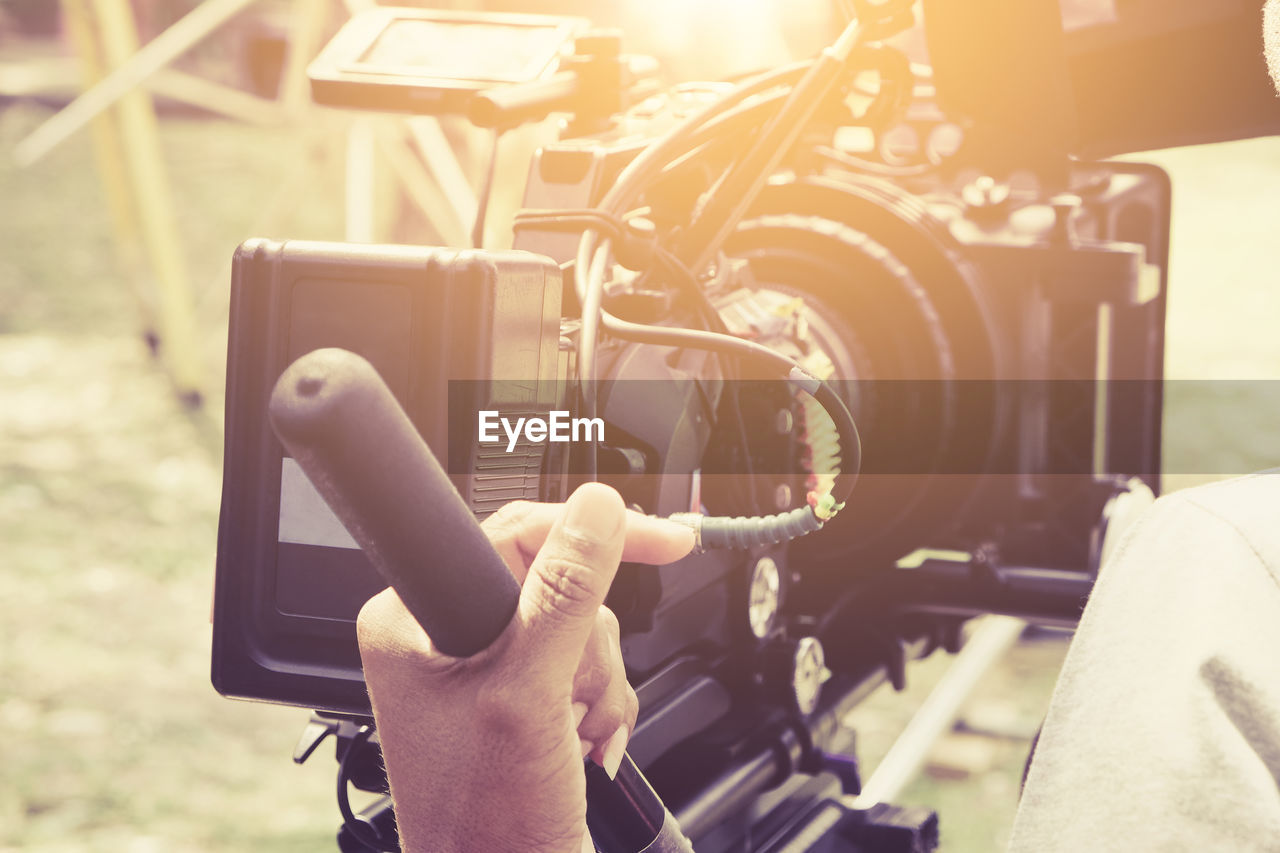 Cropped image of man using video camera on sunny day