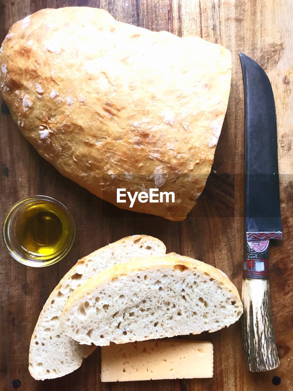 Directly above shot of bread and knife on wooden table