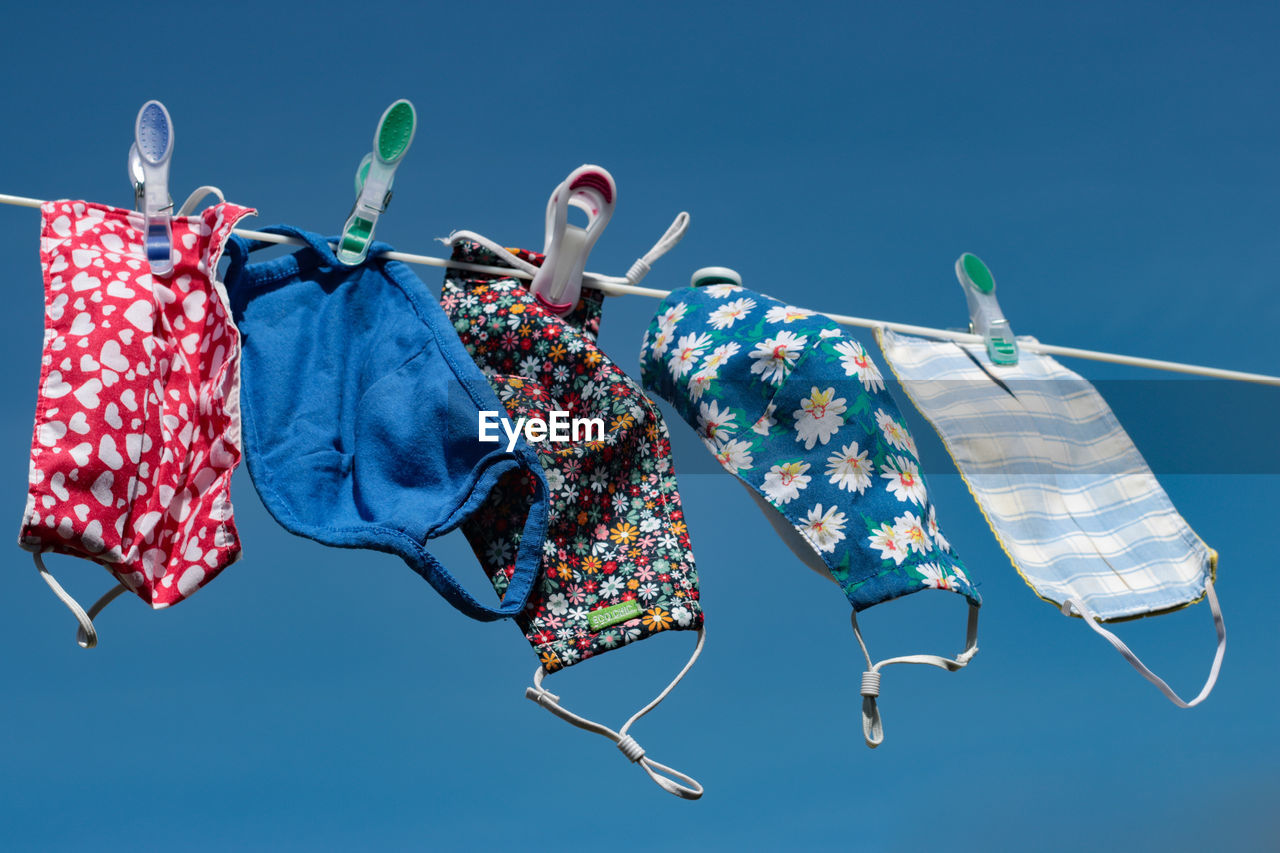 Low angle view of clothes hanging against blue sky