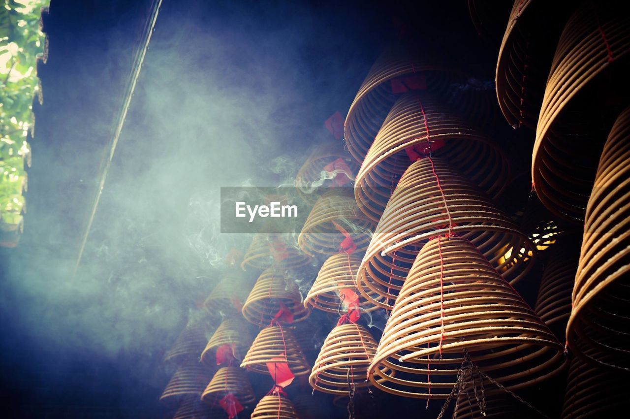 Low angle view of spiral incenses at temple