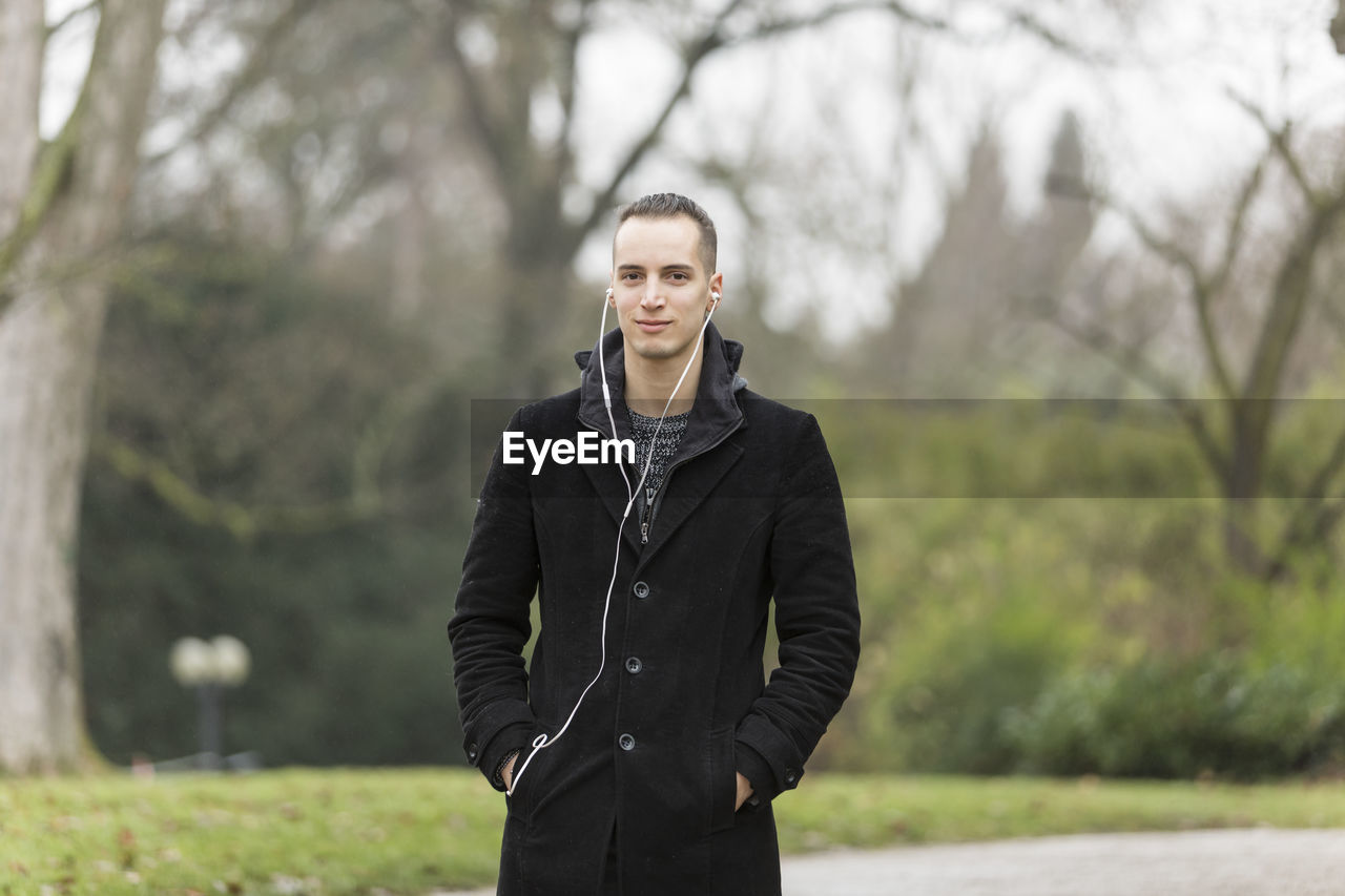 Portrait of man standing against trees