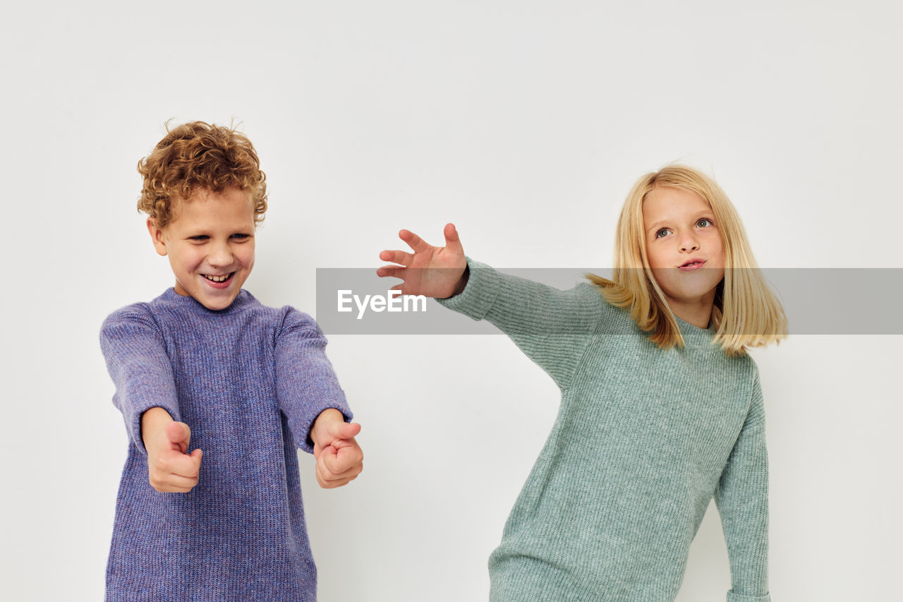 Smiling sibling playing against white background