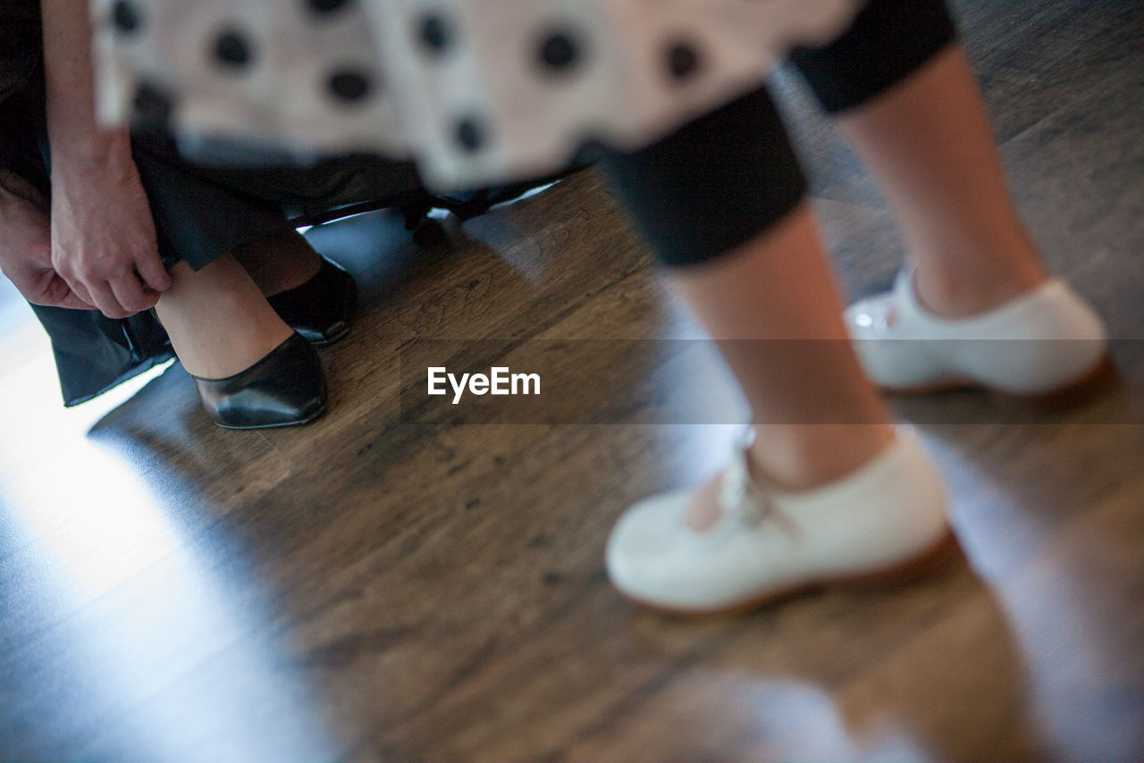 low section of woman standing on hardwood floor