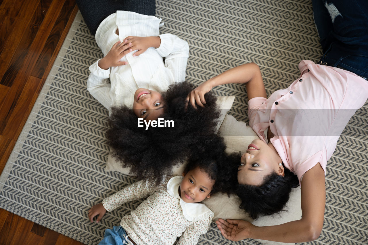 HIGH ANGLE VIEW OF WOMAN LYING DOWN ON FLOOR