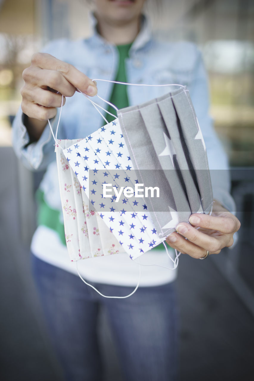 Close-up of woman holding flu mask