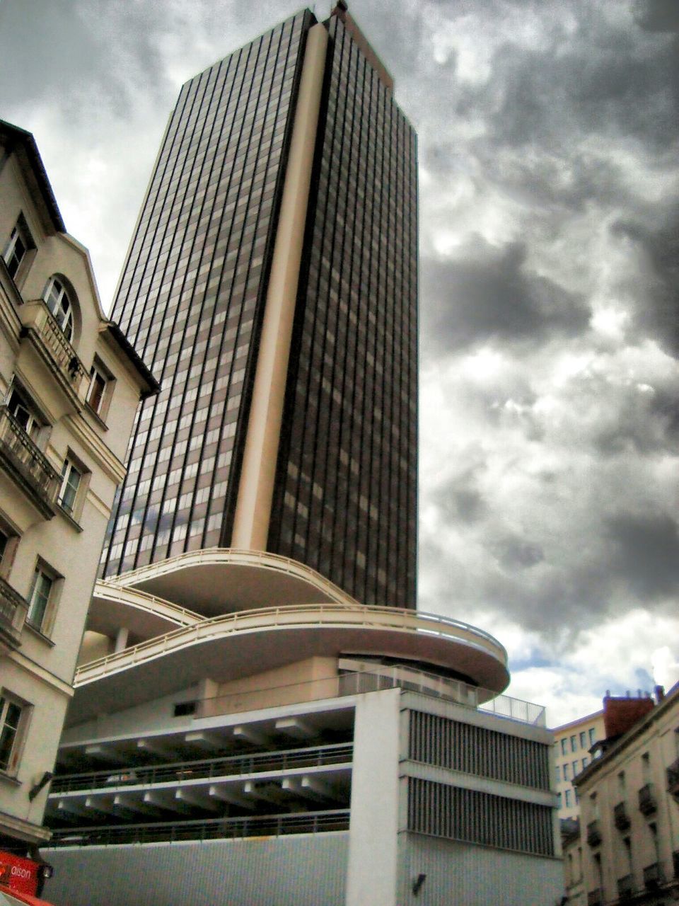 LOW ANGLE VIEW OF MODERN BUILDING AGAINST CLOUDY SKY