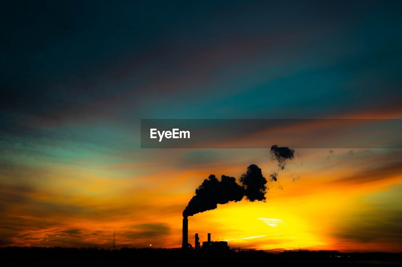 SILHOUETTE OF SMOKE EMITTING FROM CHIMNEY AGAINST SKY
