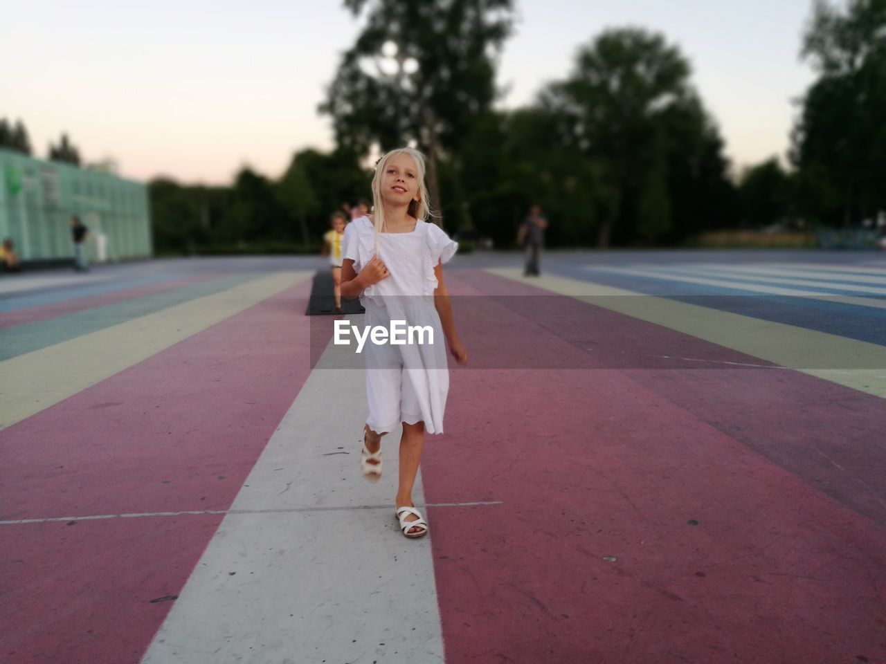 Thoughtful girl walking on running track at stadium during sunset