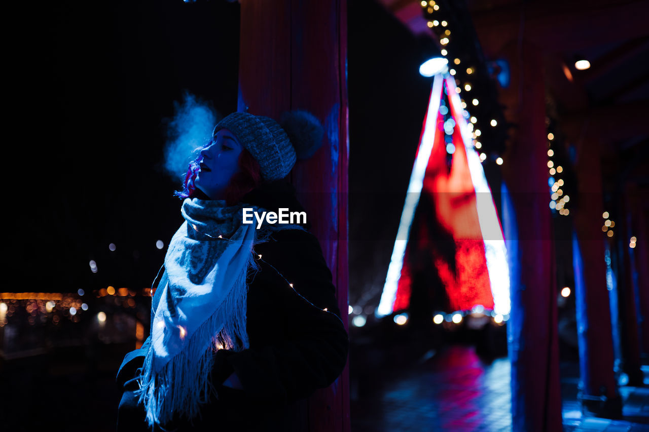 Woman looking at illuminated stage at night