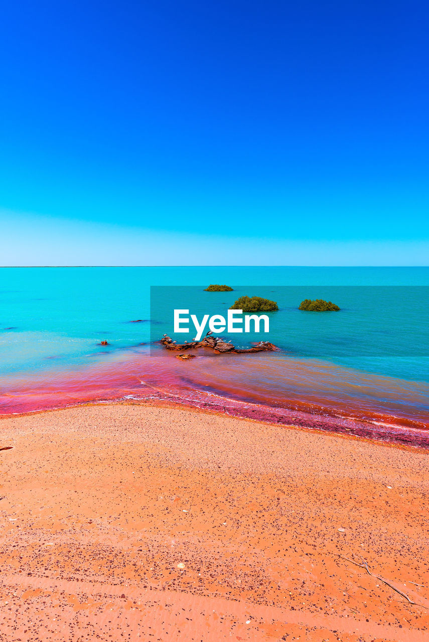 Scenic view of sea against clear blue sky