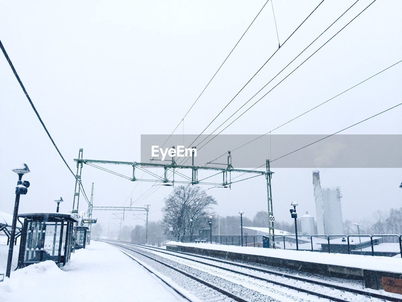 Snow covered railroad station against sky