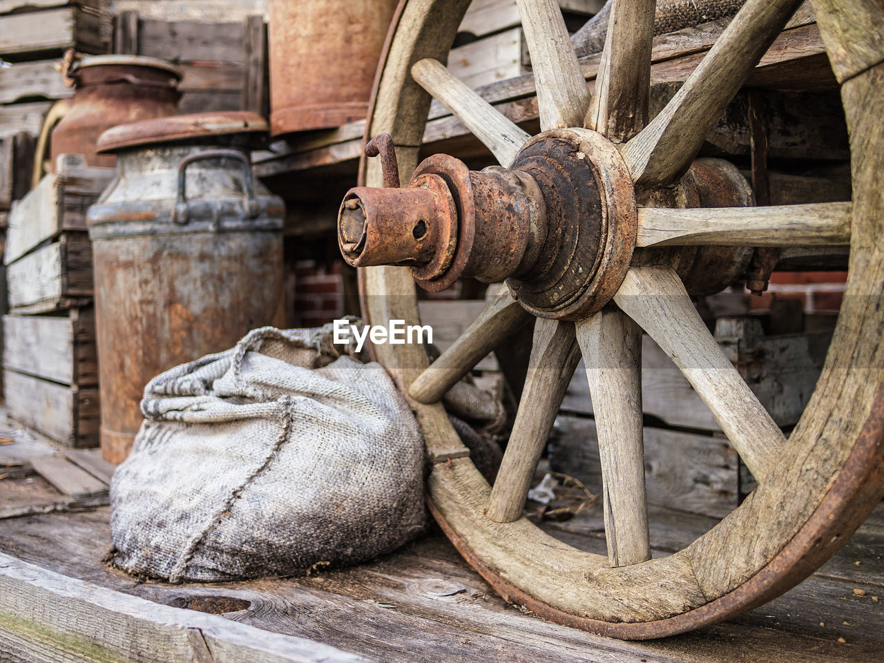 Close-up of wooden wheel by sack