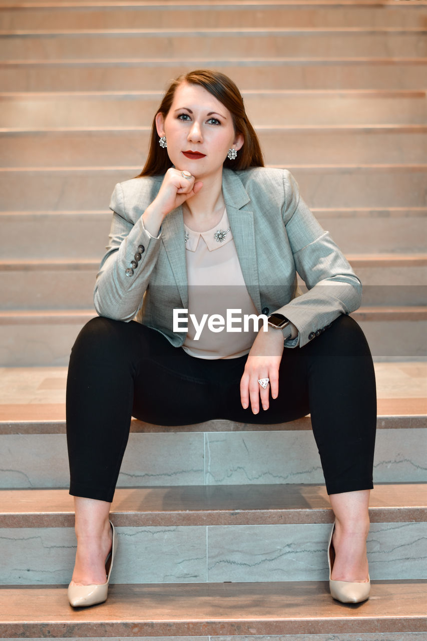 Portrait of young woman sitting on staircase