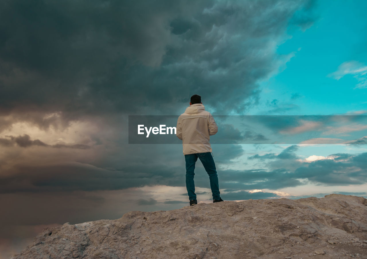 Rear view of man standing on rock