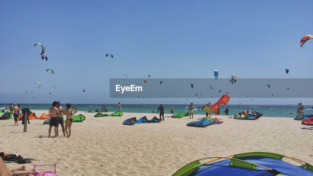 People enjoying at beach against sky