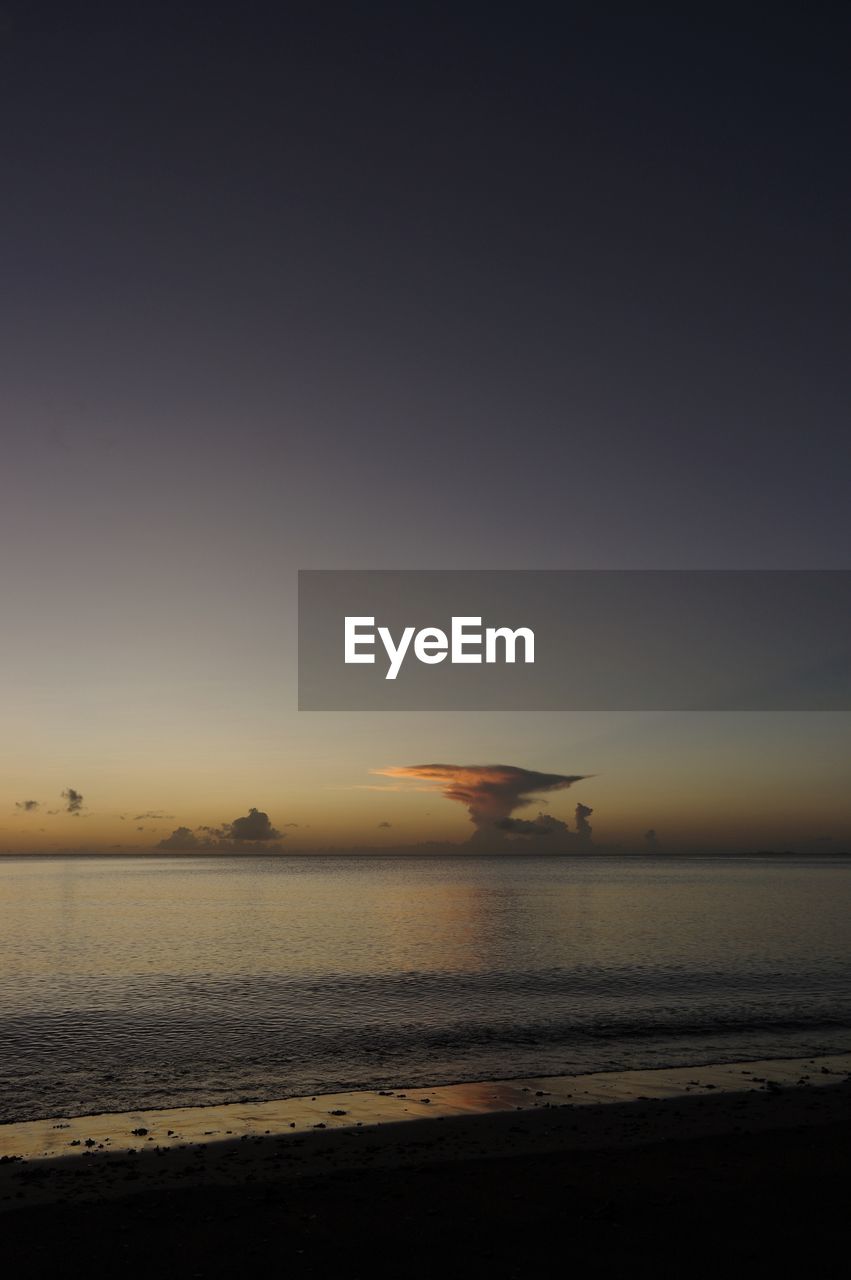 SCENIC VIEW OF BEACH AGAINST SKY AT SUNSET