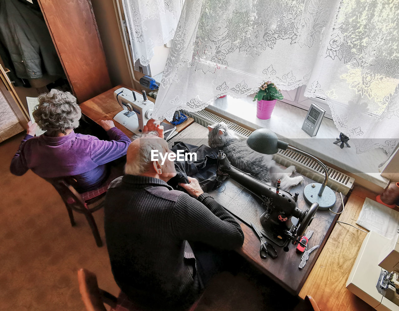 High angle view of senior couple sitting by window at home