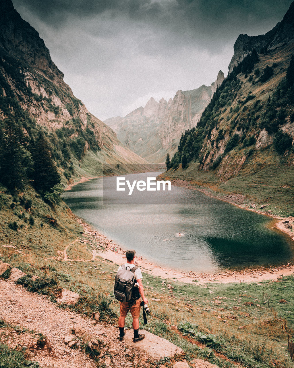 Man looking at lake against mountains