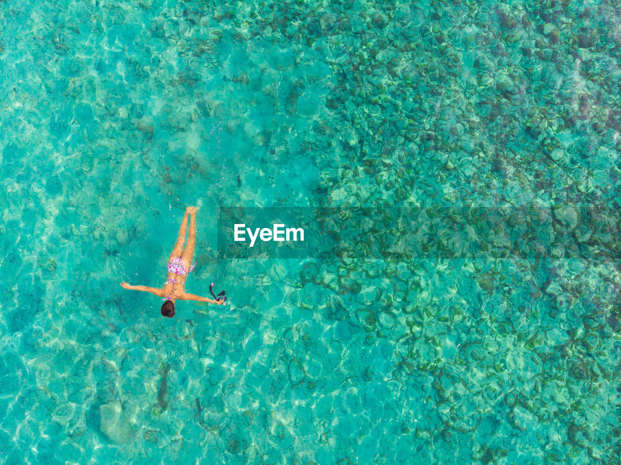 High angle view of woman wearing bikini swimming in sea