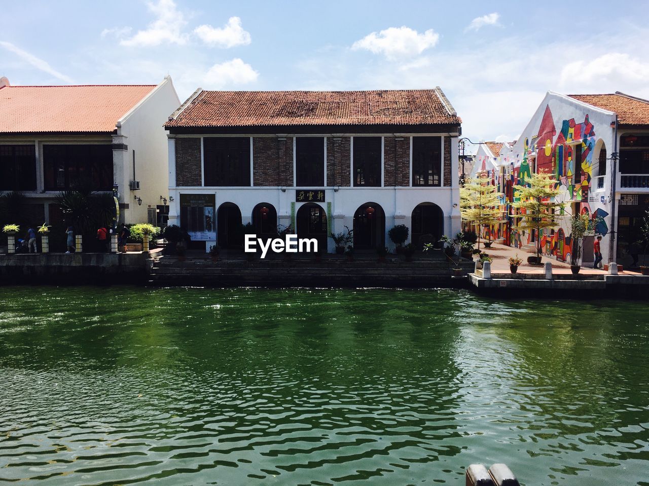 PEOPLE AT SWIMMING POOL IN FRONT OF BUILDING