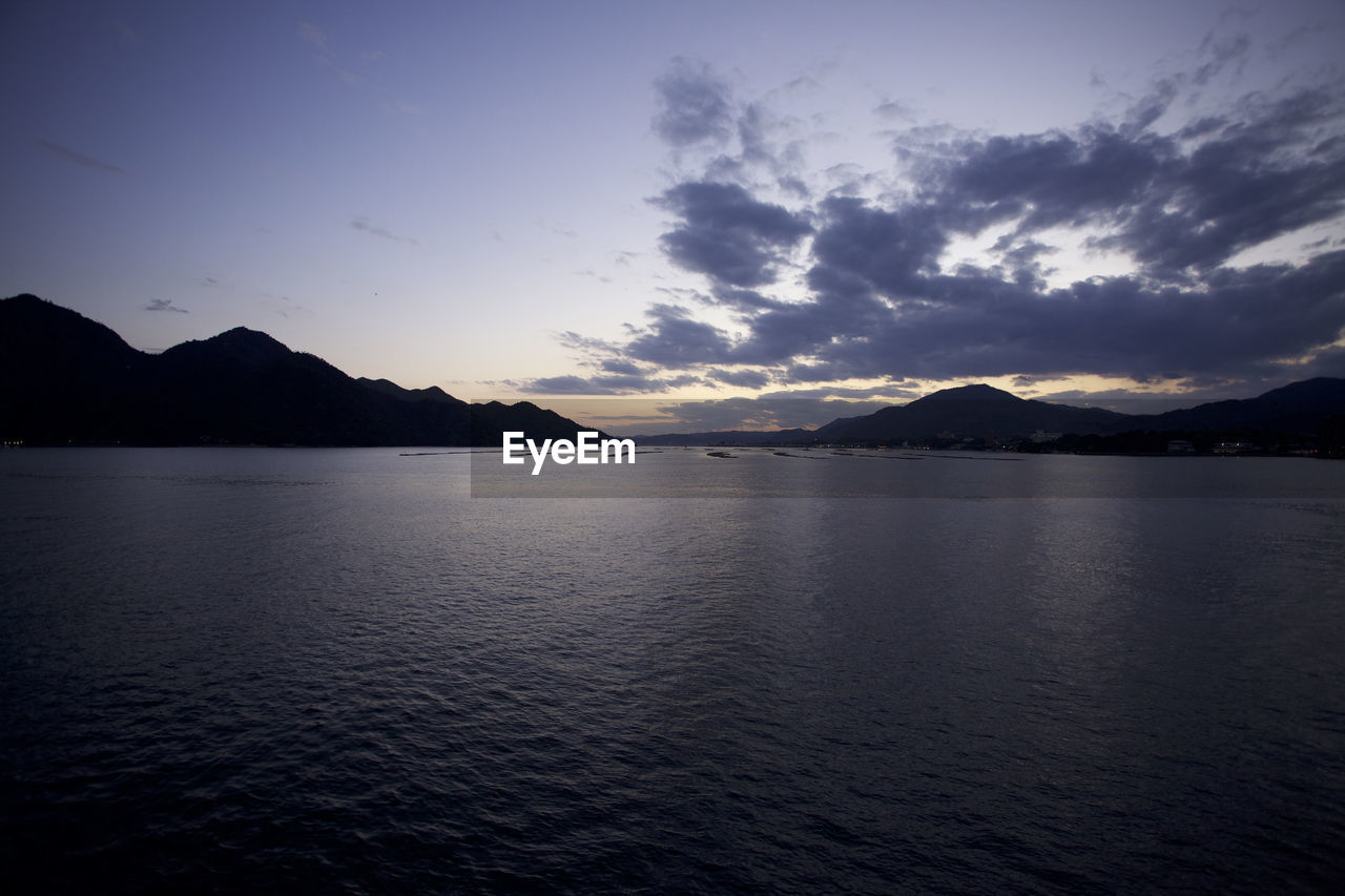 SCENIC VIEW OF LAKE BY MOUNTAINS AGAINST SKY