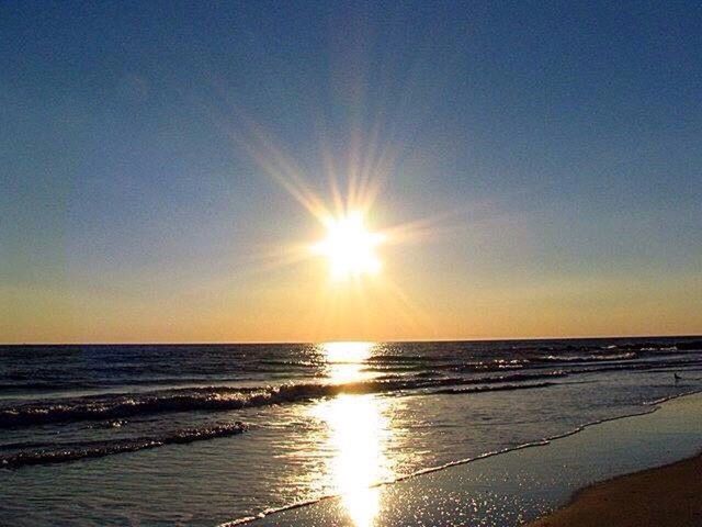 SCENIC VIEW OF BEACH AGAINST SKY AT SUNSET