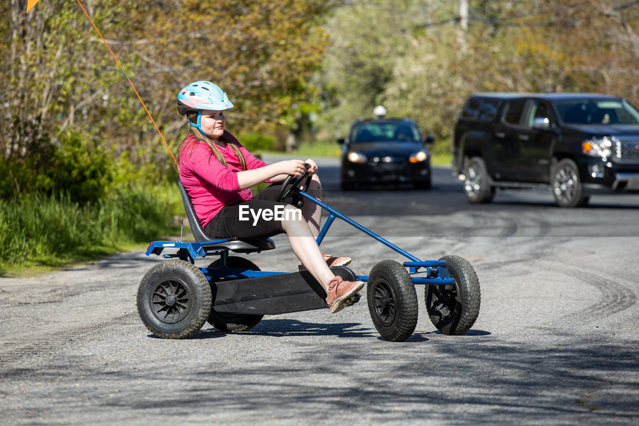 Gurl with pedal car on road