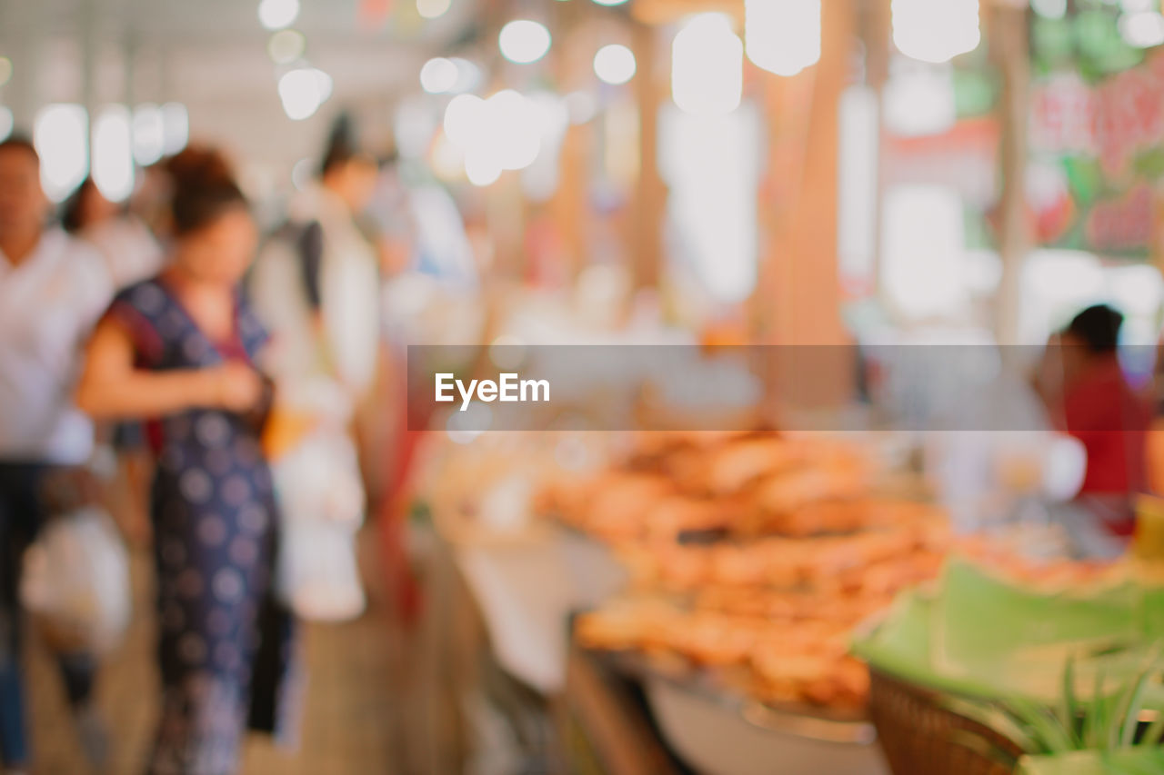 Defocused image of people at market stall