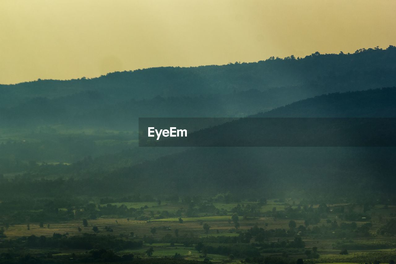 SCENIC VIEW OF LANDSCAPE AGAINST MOUNTAINS DURING SUNSET