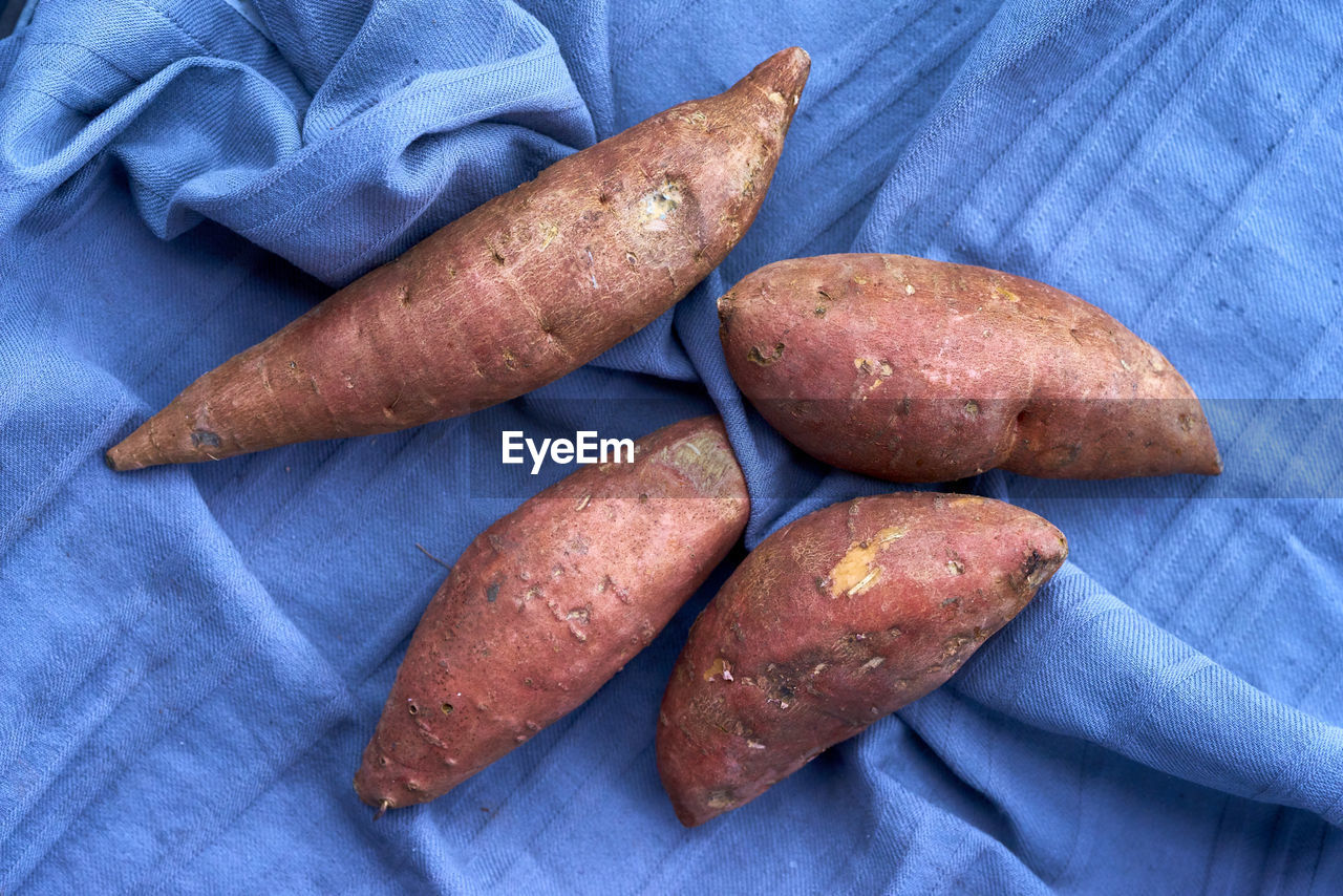 Close-up of sweet potatoes on blue fabric