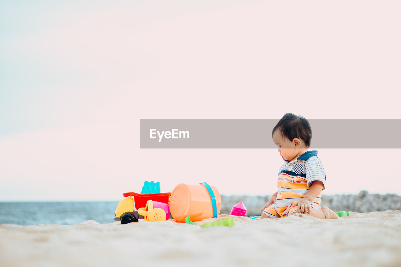 BOY WITH TOY ON BEACH