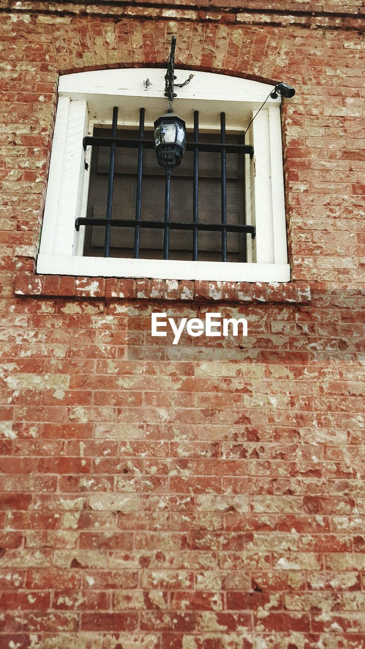 Low angle view of window on brick wall