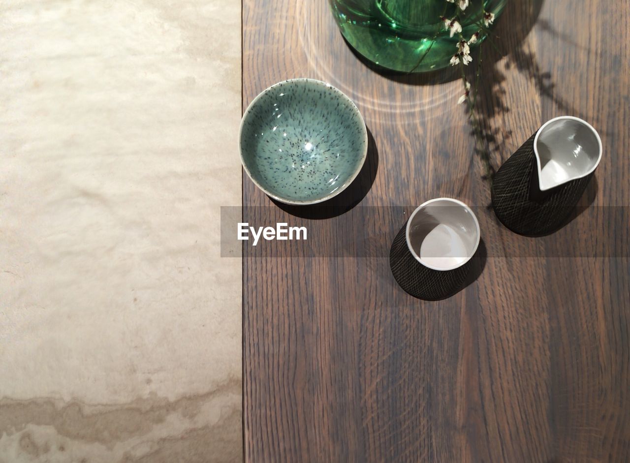 Directly above shot of pitcher and bowls on wooden table