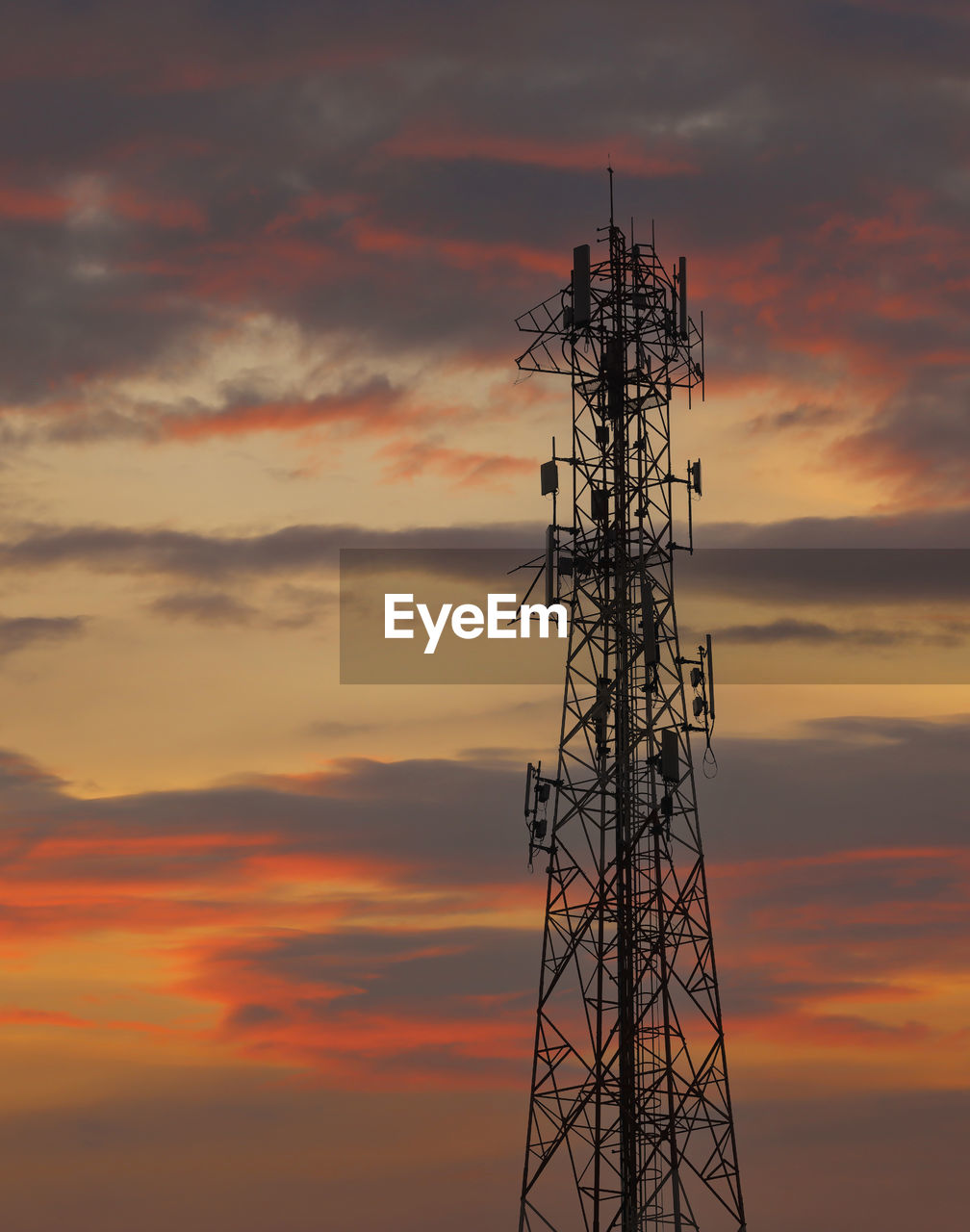 low angle view of electricity pylon against orange sky during sunset